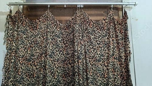 Leopard print curtains with a draped design hang elegantly on a metal rod, adding a touch of wild style to any room's decor. Perfect for fashion forward interior design enthusiasts.