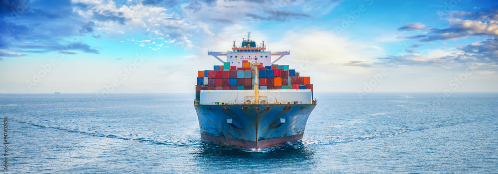 Front view of a large container cargo ship sailing over the ocean as a banner for shipping and industry
