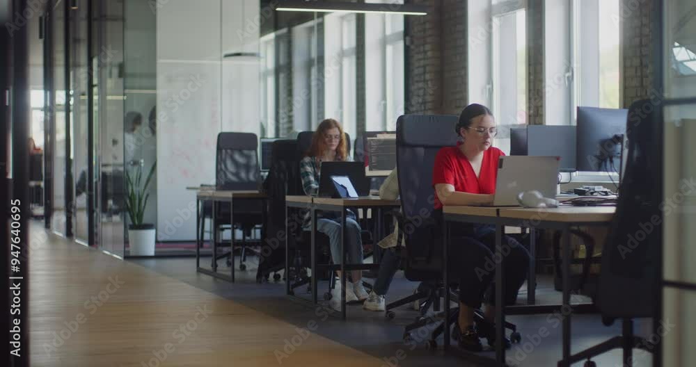 Two young business colleagues walking through a modern startup office and engaging in a dynamic discussion about various business challenges. Two young business colleagues walking through a modern startup office and engaging in a dynamic discussion about various business challenges.