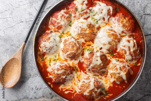 Baked cheesy meatballs casserole with tomato sauce in the oven dishn close-up on the table. Horizontal top view from above photo