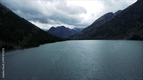 Amazing view of the turquoise Kucherlin Lake in Altai. An aerial view of a beautiful alpine valley with steep cliffs and overgrown coniferous forest. Altai Mountains photo