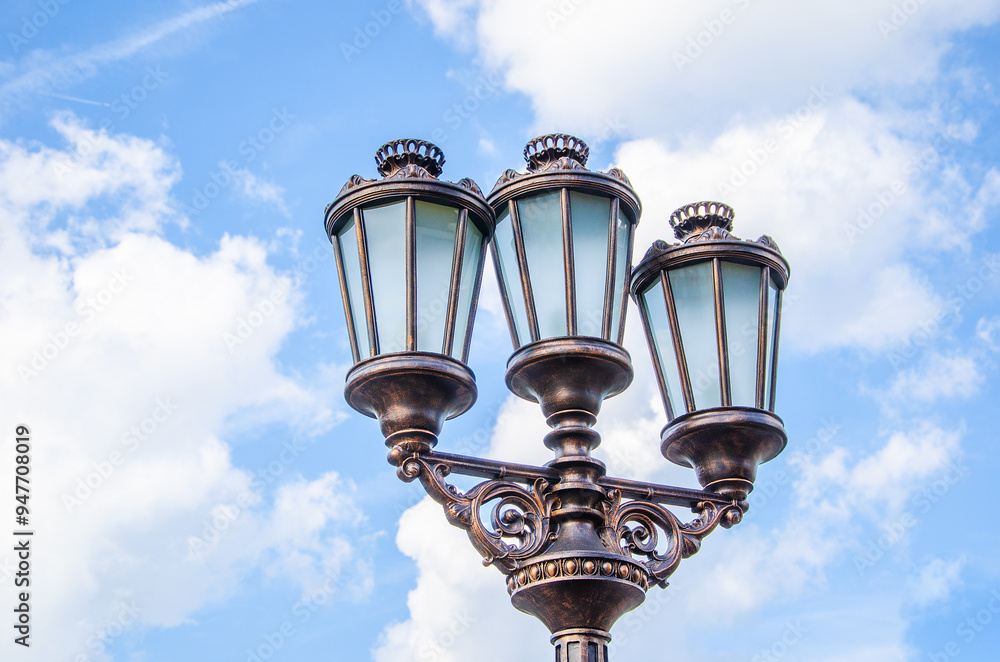 Street lamp with three lamps against blue sky. Street lamp with three lamps against blue sky.