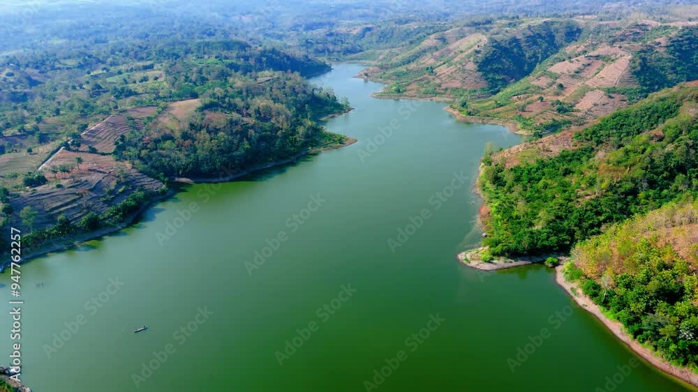 Drone flying through green lake with natural forest Drone flying through green lake with natural forest