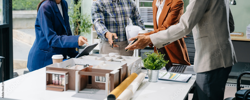 Asian architects and designers brainstorming and collaborating in a modern office, utilizing models and plans Asian architects and designers brainstorming and collaborating in a modern office, utilizing models and plans