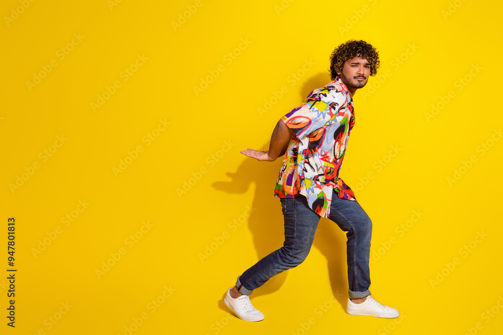 Full size photo of nice young man carry empty space wear shirt isolated on yellow color background Full size photo of nice young man carry empty space wear shirt isolated on yellow color background