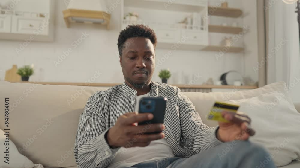 Pay by card in online services, African man inputting data of credit card in app . Internet fraud and data theft, cybercrime and cyber security, young adult black male person shopping online from home Pay by card in online services, African man inputting data of credit card in app . Internet fraud and data theft, cybercrime and cyber security, young adult black male person shopping online from home