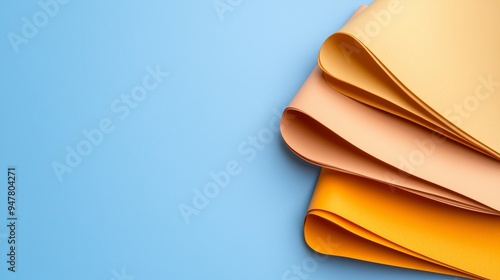 A vibrant display of colored sheets arranged elegantly on a blue background, ideal for creative projects and designs.