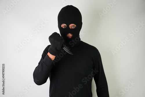 Armed and Dangerous Young Adult black masked robber brandished a knife at the victim in an attempt to steal valuable items.  photo