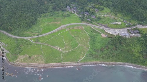 Aerial view of shiroyone senmaida rice terraces with lush green fields and a serene coastal backdrop, Wajima, Japan. photo