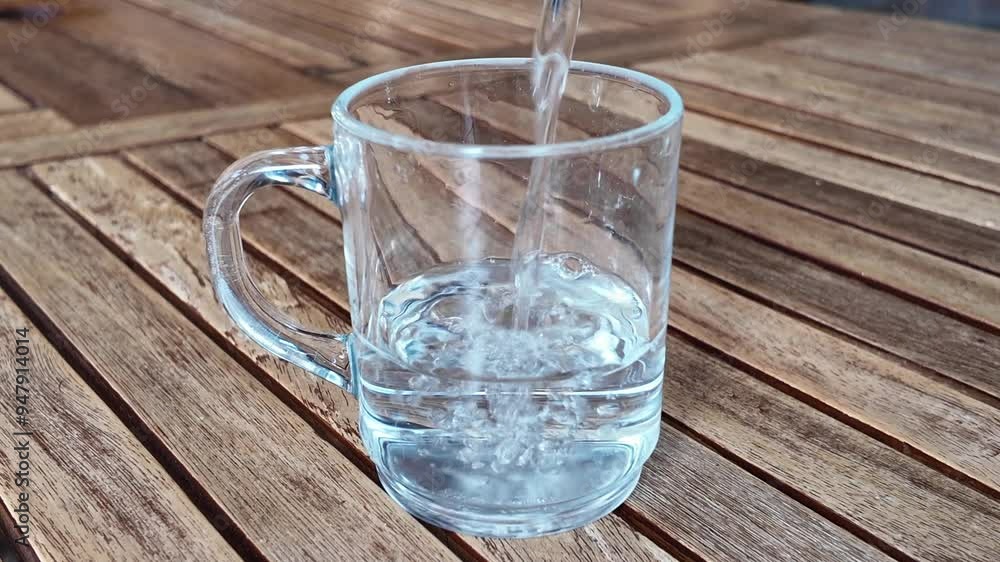 Llenando un vaso de agua sobre una mesa Llenando un vaso de agua sobre una mesa