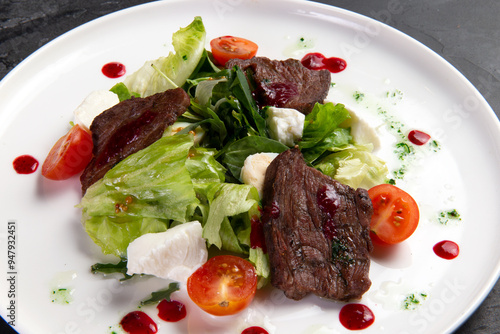 Beef salad in a plate. on a dark background.