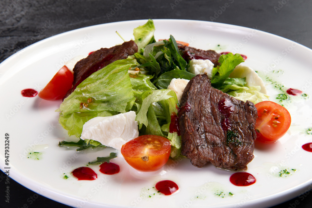 Beef salad in a plate. on a dark background. Beef salad in a plate. on a dark background.