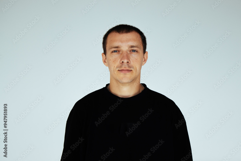 Man in black shirt a plain background, look directly at camera. Man in black shirt a plain background, look directly at camera.