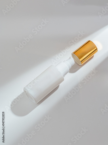 Cosmetic bottle with a gold lid on a white background with a sha