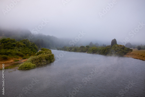 Water evaporates off river during foggy day on California coast photo