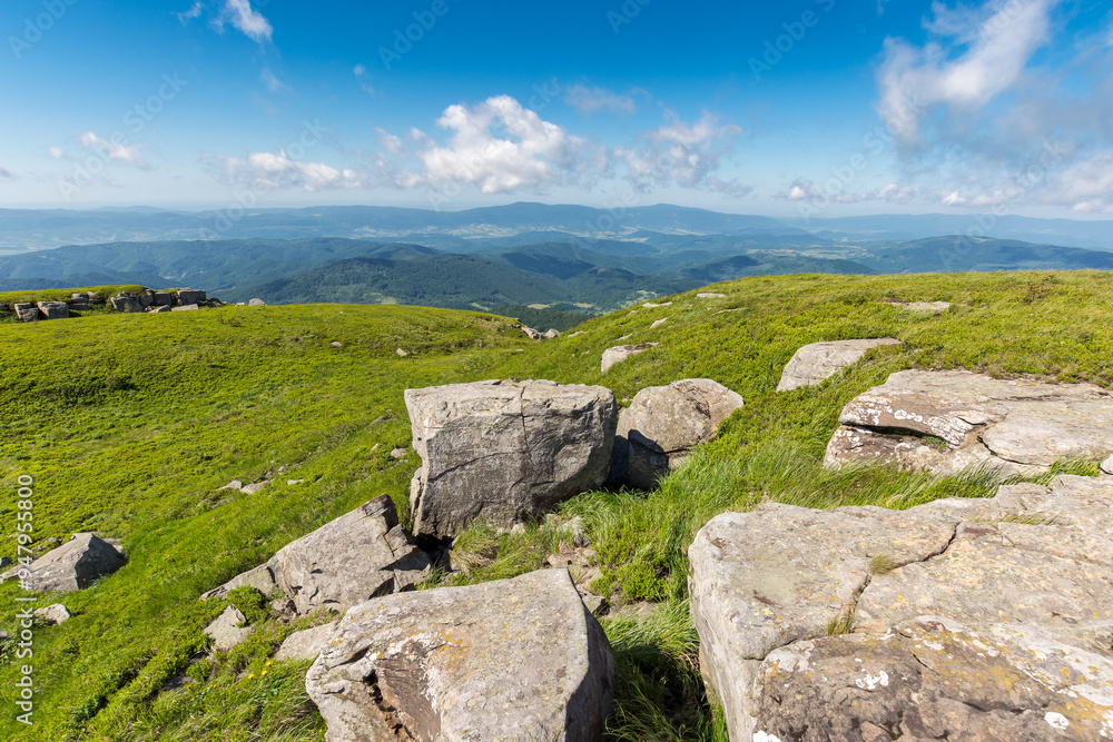 mountain summer landscape. meadow with huge stones among the grass on top of a hill near the slope of mount smooth. view in to the distant valley. sunny weather mountain summer landscape. meadow with huge stones among the grass on top of a hill near the slope of mount smooth. view in to the distant valley. sunny weather