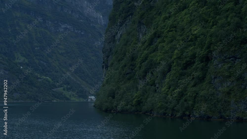 Scenic fjord surrounded by towering green cliffs and calm waters under an overcast sky Scenic fjord surrounded by towering green cliffs and calm waters under an overcast sky