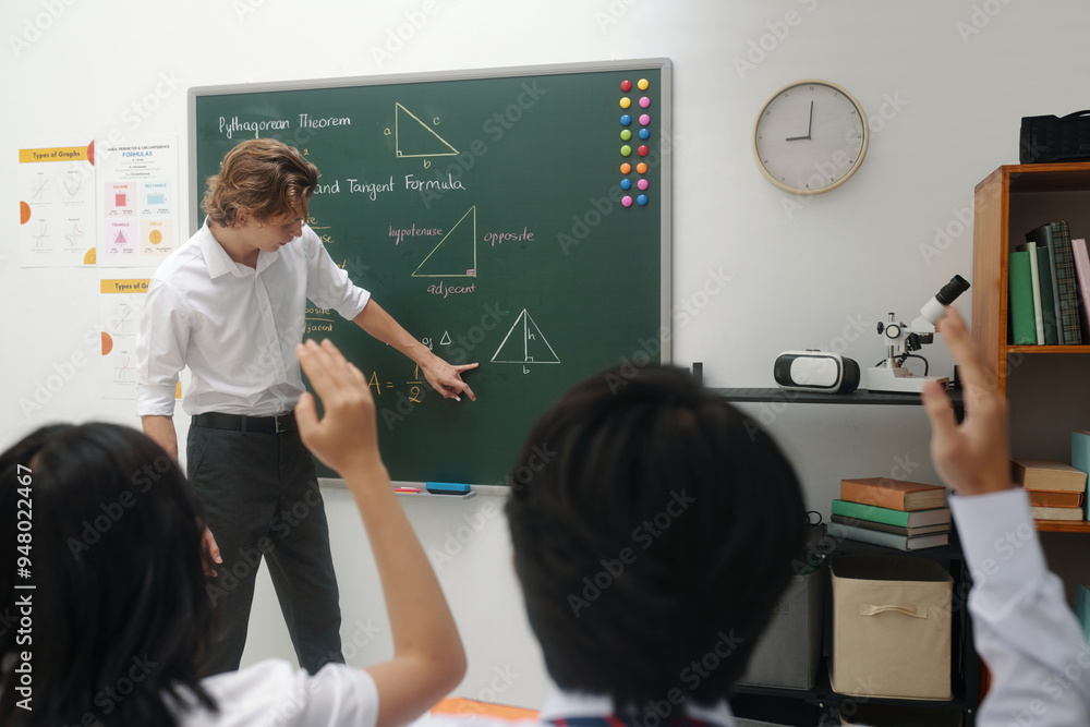 Teacher explaining Pythagorean theorem to students while writing on ...