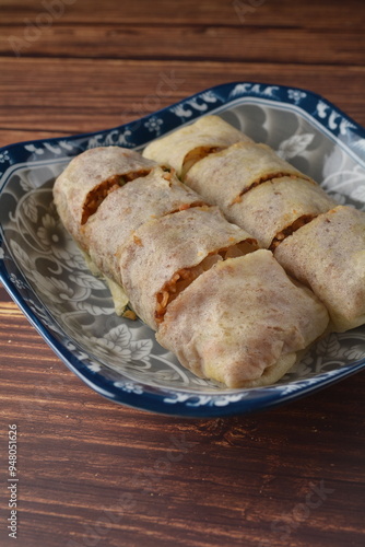Homemade traditional asian food nyonya Popiah Spring Roll fresh vegetables, bean curd, fried shallots, dried shrimp, sweet chili paste and braised turnip on wood table vegan halal menu for cafe