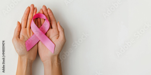 Wallpaper Mural Close-up of hands gently holding a pink ribbon, symbolizing support and awareness during Breast Cancer Awareness Month, with a minimalistic white background.
 Torontodigital.ca