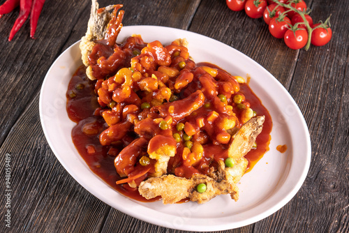 fried fish in sweet and sour sauce on wood table. Chinese food. food concept.