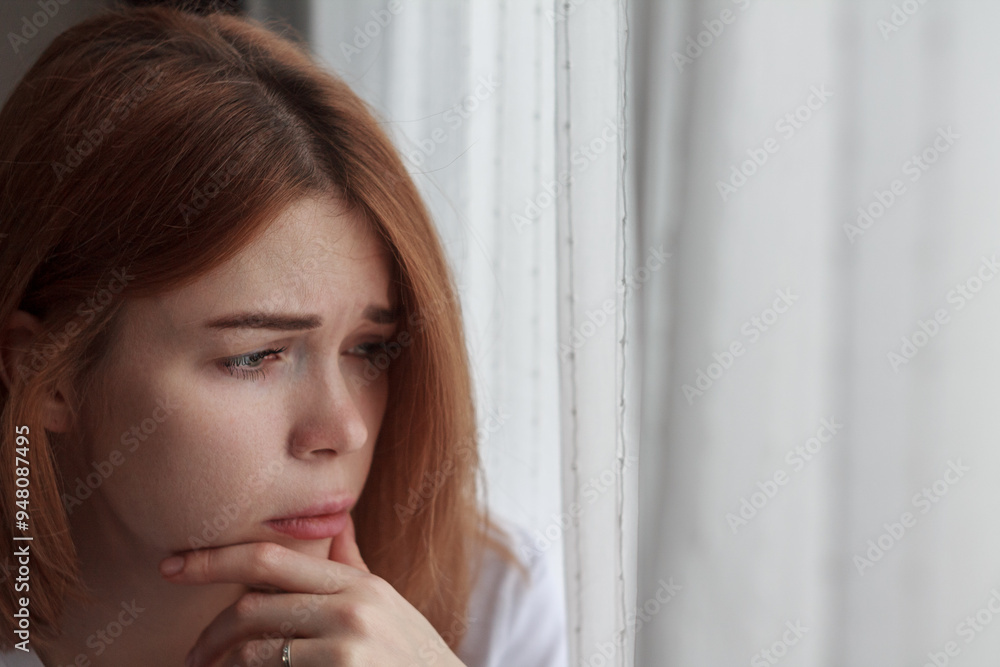 Portrait of a depressed woman: pale face, downcast eyes, expression of sadness and fatigue, shadows under the eyes, disheveled hair, blurred and dark