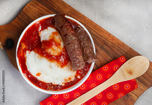 Quadro su tela Traditional South African Pap, wors and Sheba sauce flat lay with wooden board