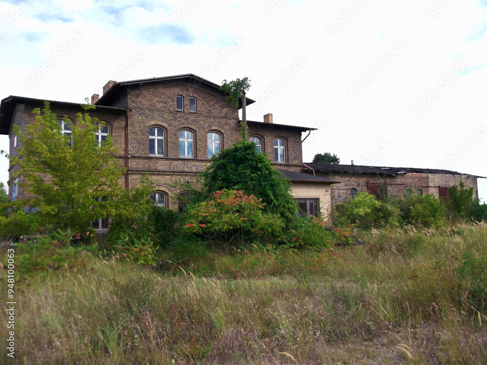 Ehemaliges Bahnhofsgebäude Haßleben mit verfallenen Bahnsteigen

