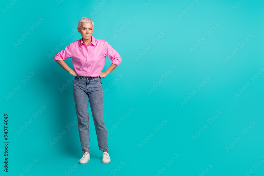 Full size photo of pretty aged woman hands waist empty space wear shirt isolated on teal color background Full size photo of pretty aged woman hands waist empty space wear shirt isolated on teal color background