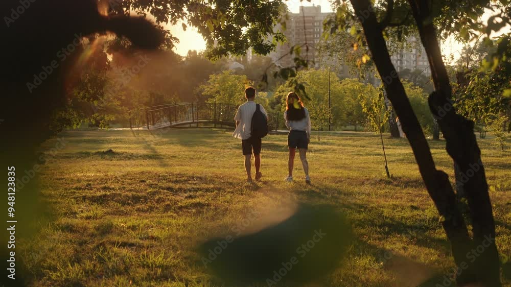 Two friends enjoy a warm summer evening together as they walk through ...