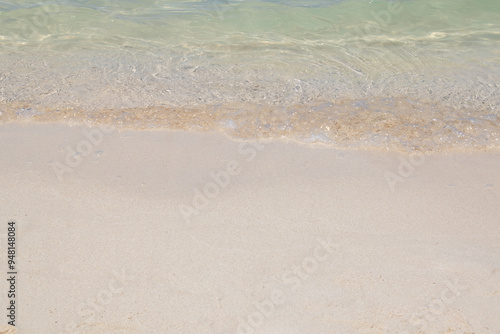 gentle waves lapping the sandy shore of a beach with clear sea water