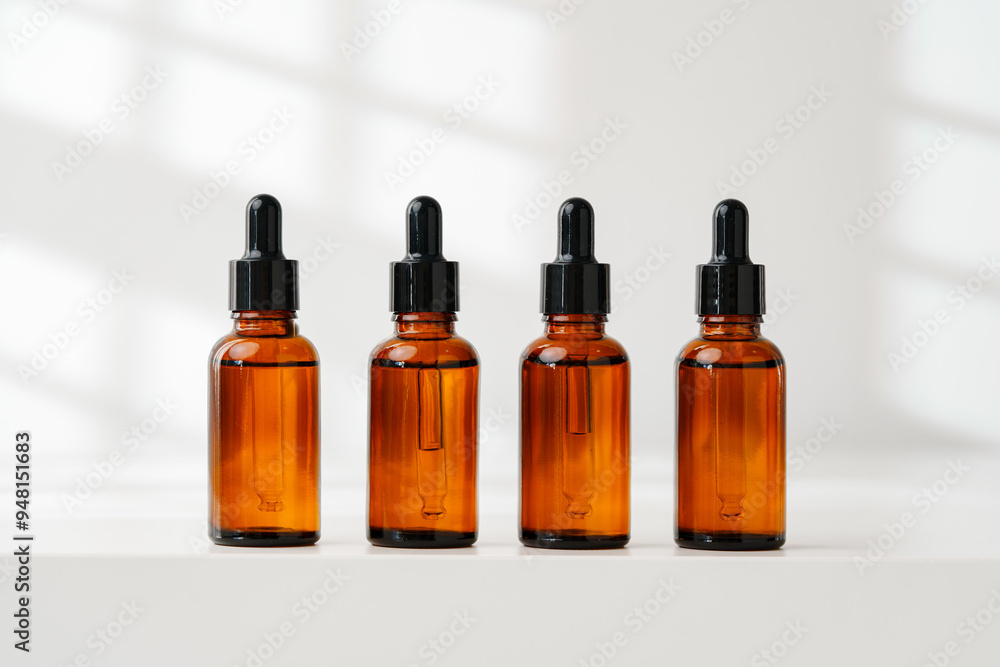 Collection of Amber Glass Dropper Bottles Displayed on a Minimalist White Surface in Natural Light Collection of Amber Glass Dropper Bottles Displayed on a Minimalist White Surface in Natural Light