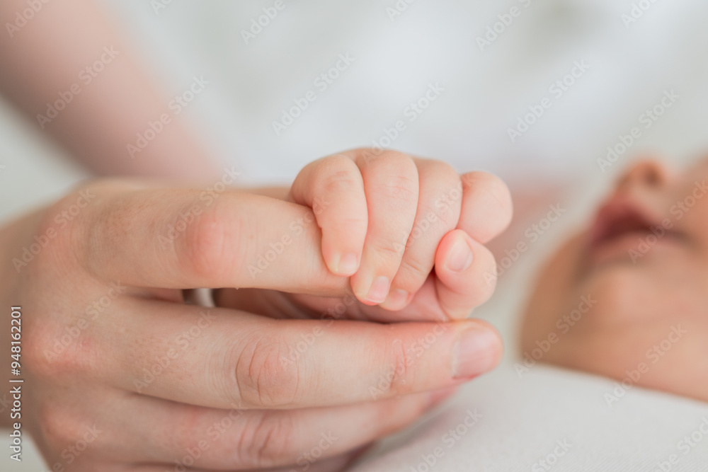 Happy family. Tiny newborn infant baby little hand on mother hand palm. Newborn baby holding parent finger after birth. Mom baby at home. Support protection of new life. Handle with care Happy family. Tiny newborn infant baby little hand on mother hand palm. Newborn baby holding parent finger after birth. Mom baby at home. Support protection of new life. Handle with care