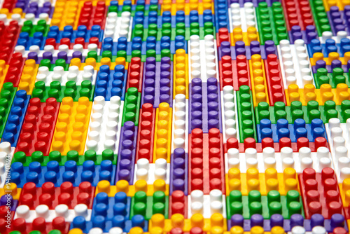 Abstract background texture of colored constructor blocks. Background of colorful plastic part of constructor. Pile of colored toy bricks.