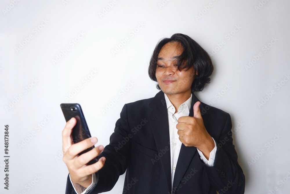 a young Indonesian man with long hair wearing a black suit carries documents required for work on an isolated white background a young Indonesian man with long hair wearing a black suit carries documents required for work on an isolated white background