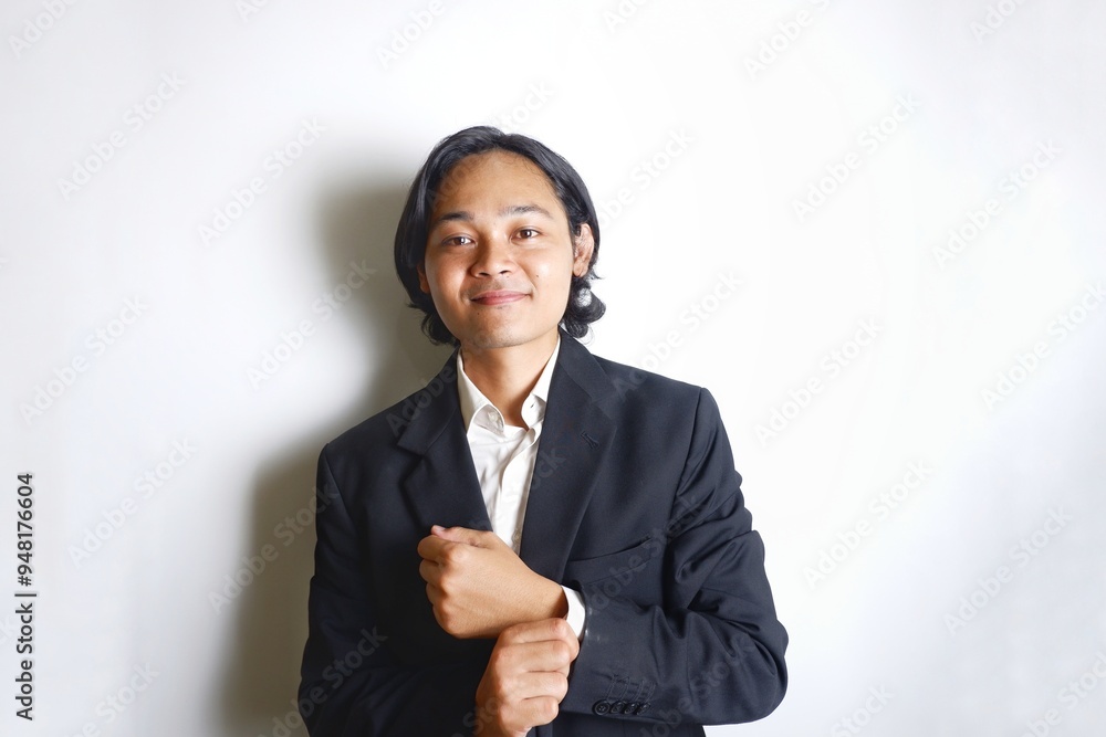 a young Indonesian man with long hair wearing a black suit carries documents required for work on an isolated white background a young Indonesian man with long hair wearing a black suit carries documents required for work on an isolated white background
