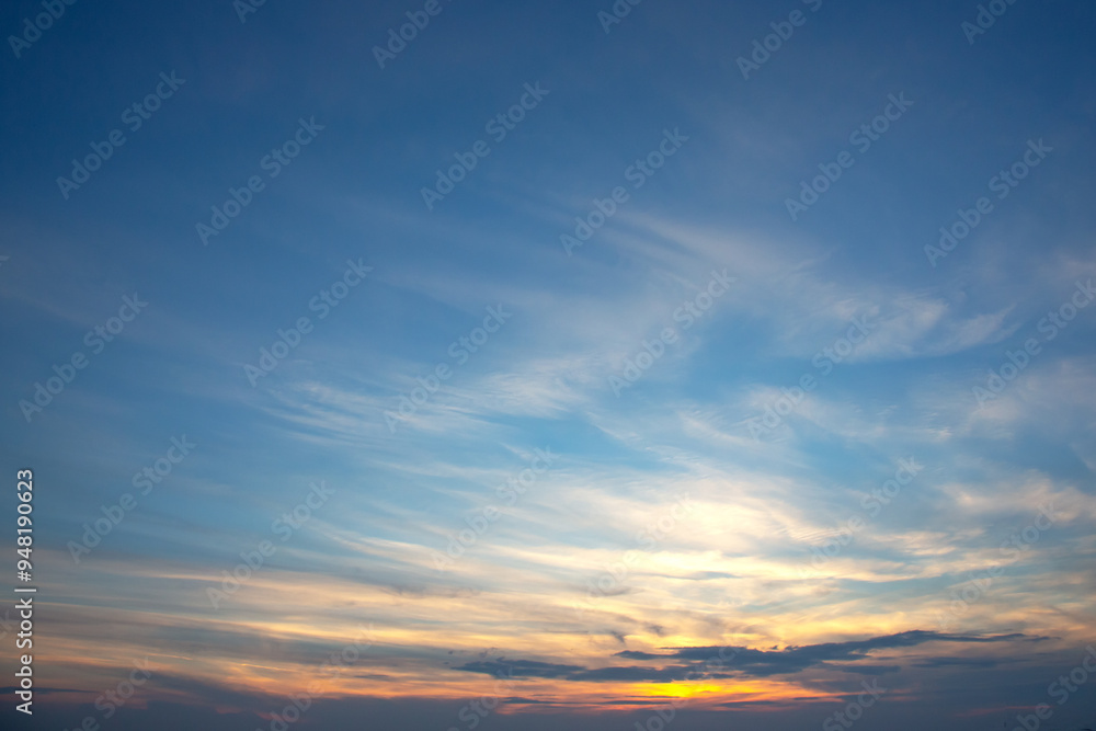 Obraz premium peaceful post-sunset sky, painted in soft pastel shades of pink and purple, with wispy clouds gently illuminated by the fading sunlight, evoking a tranquil evening scene