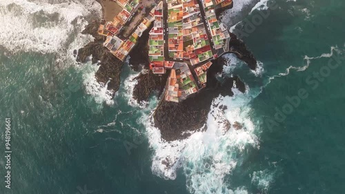 Aerial view of colorful houses along the rocky coast with turquoise water and waves, Charcones Punta Brava, Puerto de la Cruz, Spain. photo