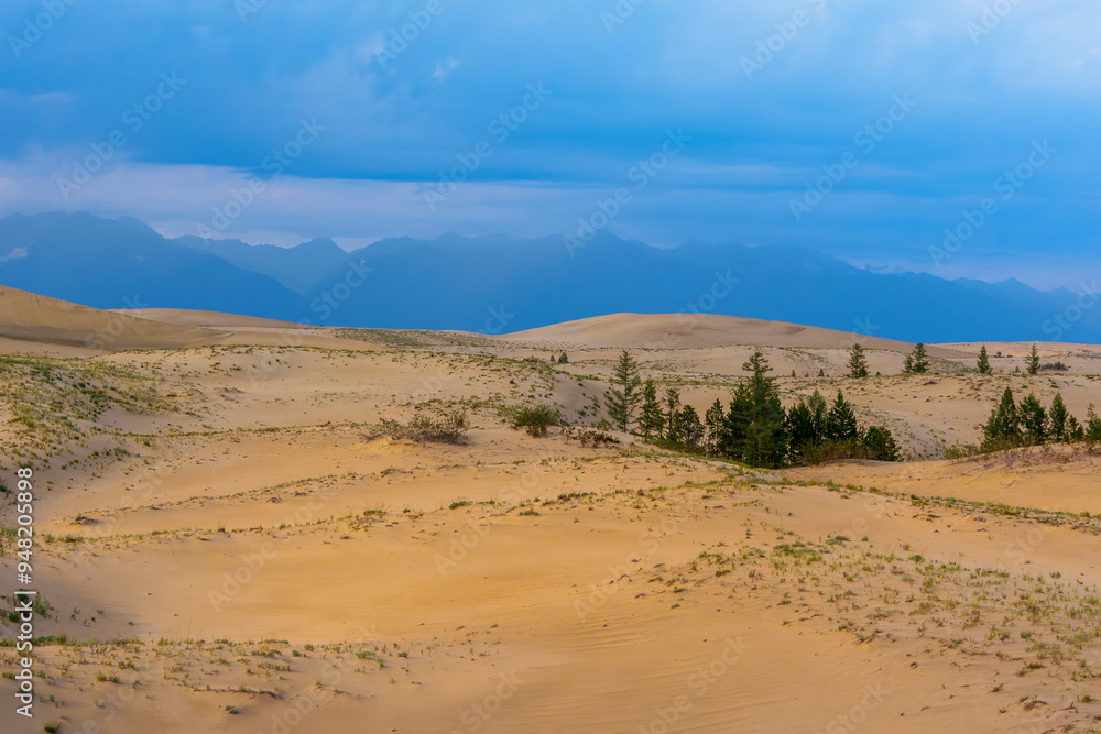 Dramatic desert dunes under sunbeams and cloudy sky Dramatic desert dunes under sunbeams and cloudy sky