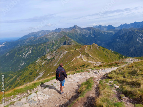 Tourist is enjoying a scenic hike on a mountain trail, surrounded by the breathtaking peaks of the tatra national park in poland