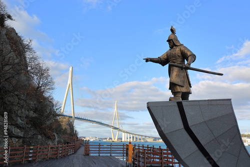 Mokpo-si, Jeollanam-do, South Korea - December 13, 2021: Winter view of statue of Admiral Yi on the deck road at Gohado Islandof against Mokpo Bridge in the background photo