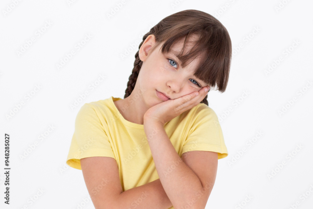 Cute woman standing in yellow t-shirt, holding palm on cheek and leaning face on it, being bored and tired of uninteresting talks, feeling indifferent to what happening over white wall Cute woman standing in yellow t-shirt, holding palm on cheek and leaning face on it, being bored and tired of uninteresting talks, feeling indifferent to what happening over white wall