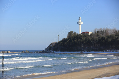 Goseong-gun, Gangwon-do, South Korea - January 21, 2022: Winter view of wave on Daejin Beach against Daejin Lighthouse photo