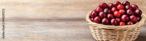 A fresh basket of ripe cranberries resting on a wooden table, showcasing their vibrant color and natural beauty.