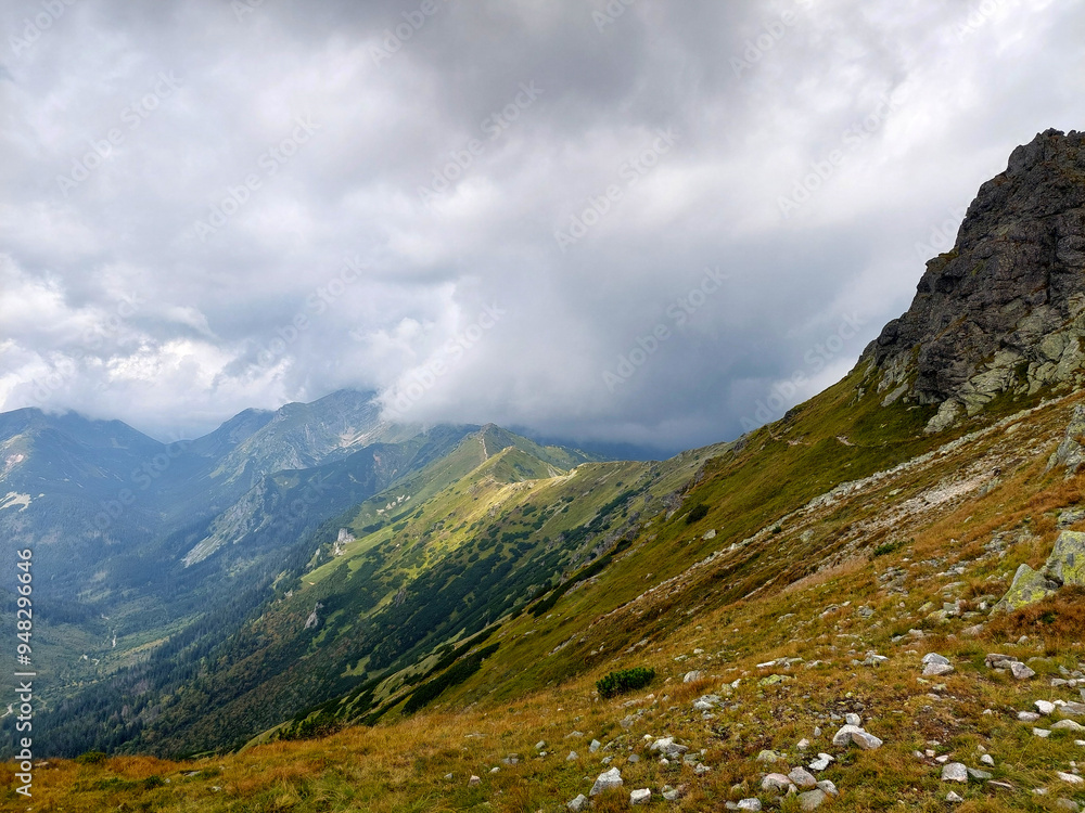 Scenic view of a winding hiking trail leading through lush green valleys and rugged peaks towards the kasprowy wierch cable car station Scenic view of a winding hiking trail leading through lush green valleys and rugged peaks towards the kasprowy wierch cable car station