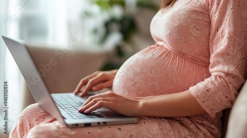 A close-up shot of a pregnant womanhands typing on a laptop, symbolizing productivity and the balance photo