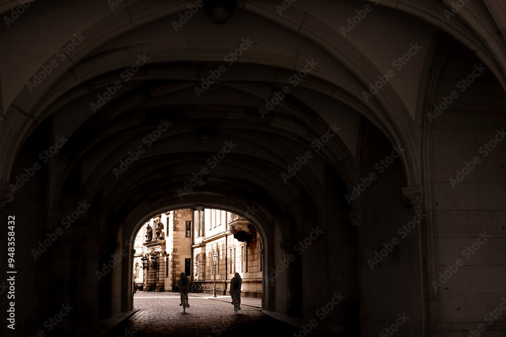 At the end of the tunnel the old city buildings and the silhouettes of two city bikers can be seen. At the end of the tunnel the old city buildings and the silhouettes of two city bikers can be seen.