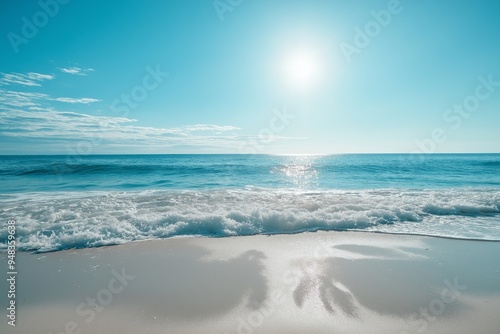 A pristine beach scene featuring gentle waves, clear skies, and the sun glistening across the horizon on a bright day.