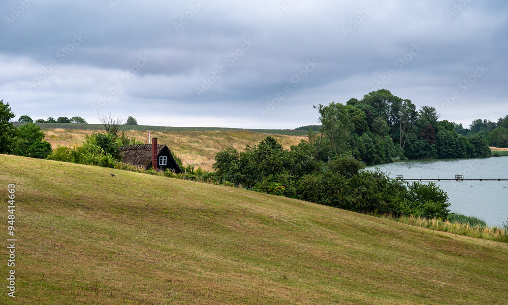 Fototapeta premium Green meadows and a water pond at the Danish countryside around Ugledige, Denmark