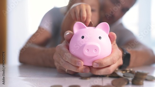 Foto Child is playing with piggy bank full of coins
